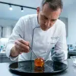 Chef en blanc travaille sur cuisine moléculaire avec sphère gélatineuse